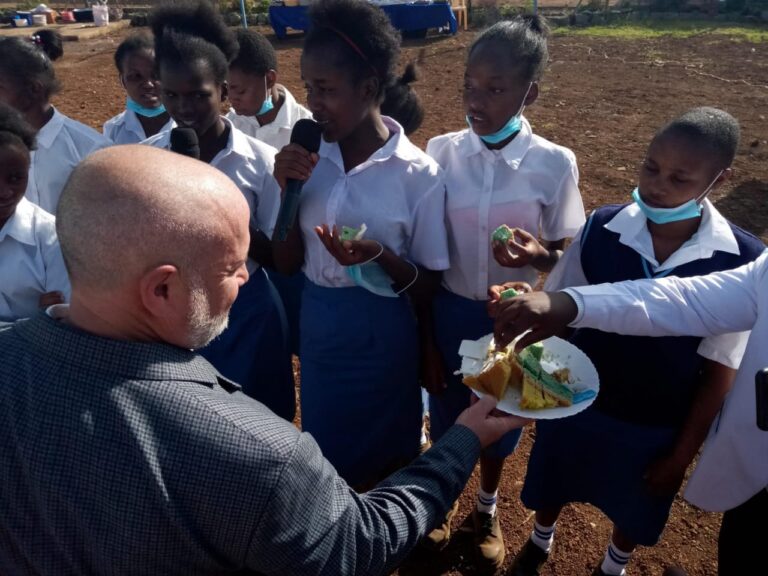 Dr. Tim hands out pieces of the cake to the students