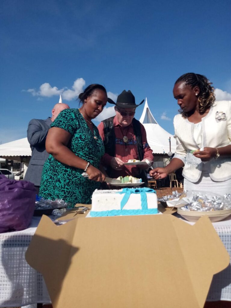 Cutting of the cake by George Hutchings, Dr. TIm Cowin, Jacinta Chengecha (executive director), and Patrick Kabiro (director of operations)